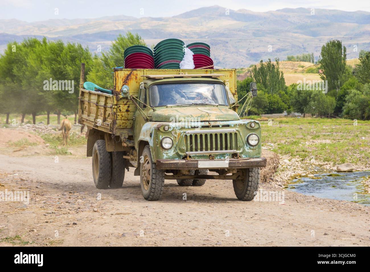 Vecchia unione sovietica caricato il carrello di guida su strada locale nella steppa kazaka Foto Stock