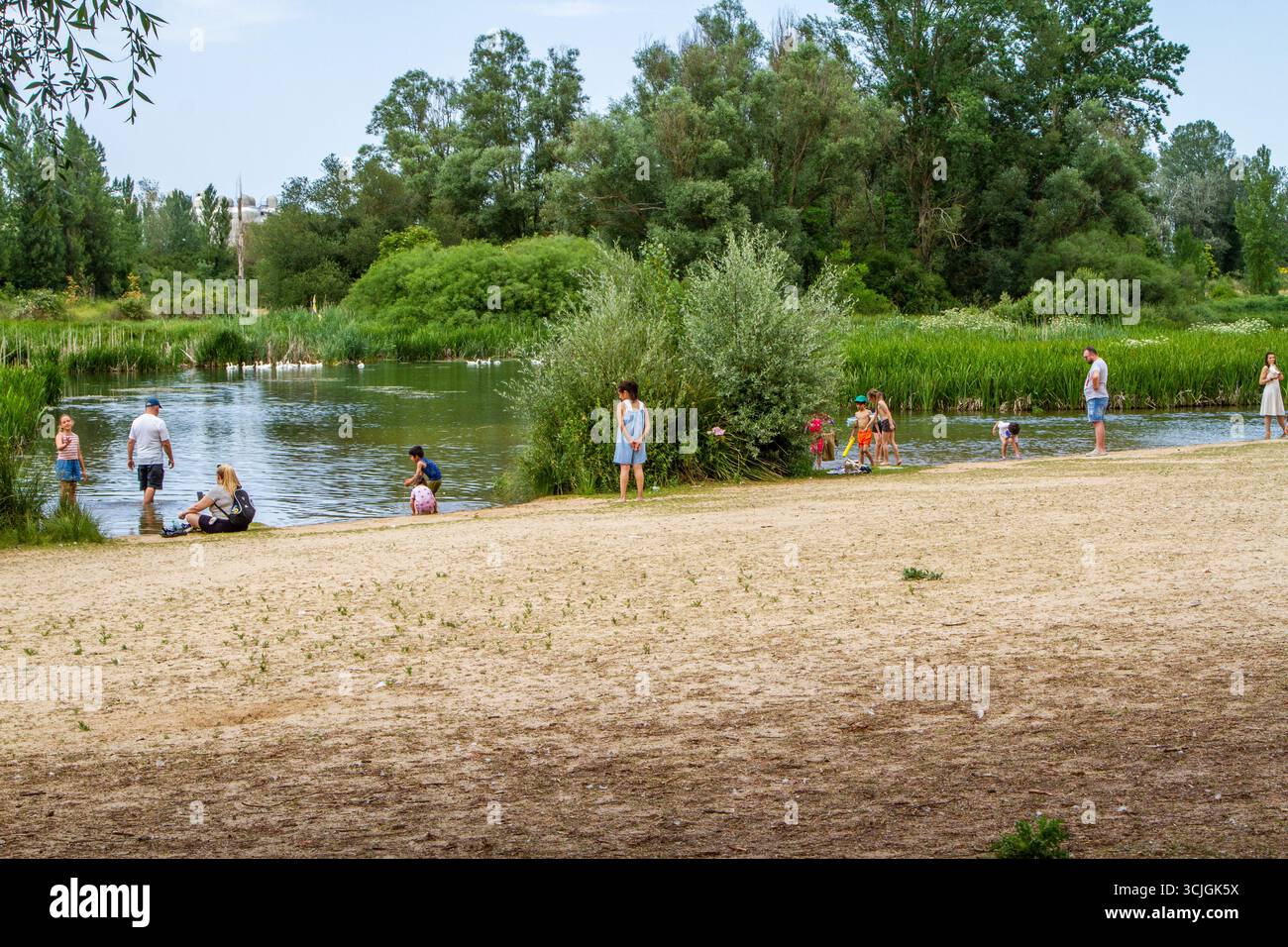 Le famiglie nella città spagnola di Burgos mantengono fresco il bagno nel fiume Arlanzón durante l'ondata di caldo dell'estate 2025 Foto Stock