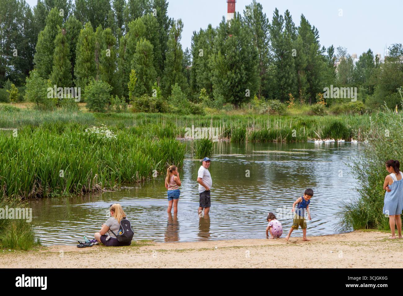 Le famiglie nella città spagnola di Burgos mantengono fresco il bagno nel fiume Arlanzón durante l'ondata di caldo dell'estate 2025 Foto Stock