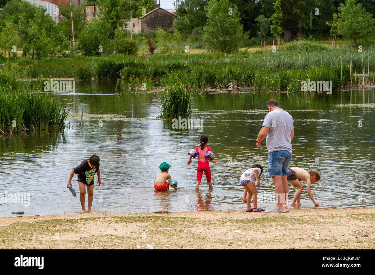 Le famiglie nella città spagnola di Burgos mantengono fresco il bagno nel fiume Arlanzón durante l'ondata di caldo dell'estate 2025 Foto Stock