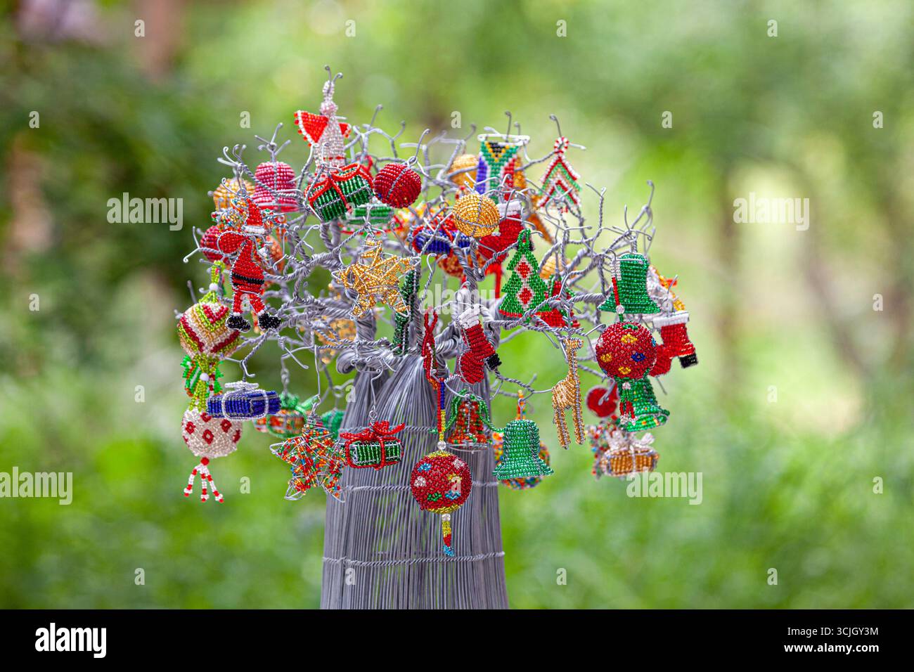 Decorazioni natalizie africane festive; albero baobab natalizio in metallo con decorazioni in filo e perline Foto Stock