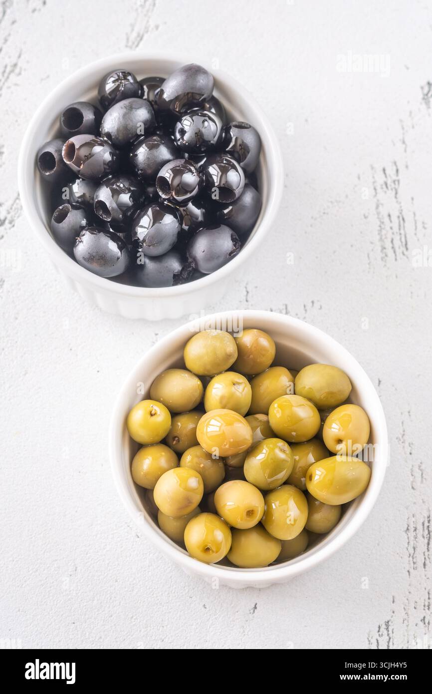 Due semplici ciotole possono contenere le morbide olive verdi e nere in una vista dall'alto minimalista Foto Stock