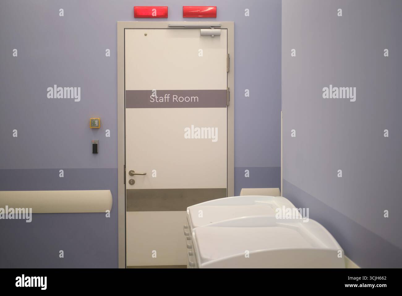 Una porta della stanza del personale in un moderno ospedale o clinica ambiente con privacy o segnali di emergenza sopra. Interni delle strutture mediche per i concetti di assistenza sanitaria. Foto Stock