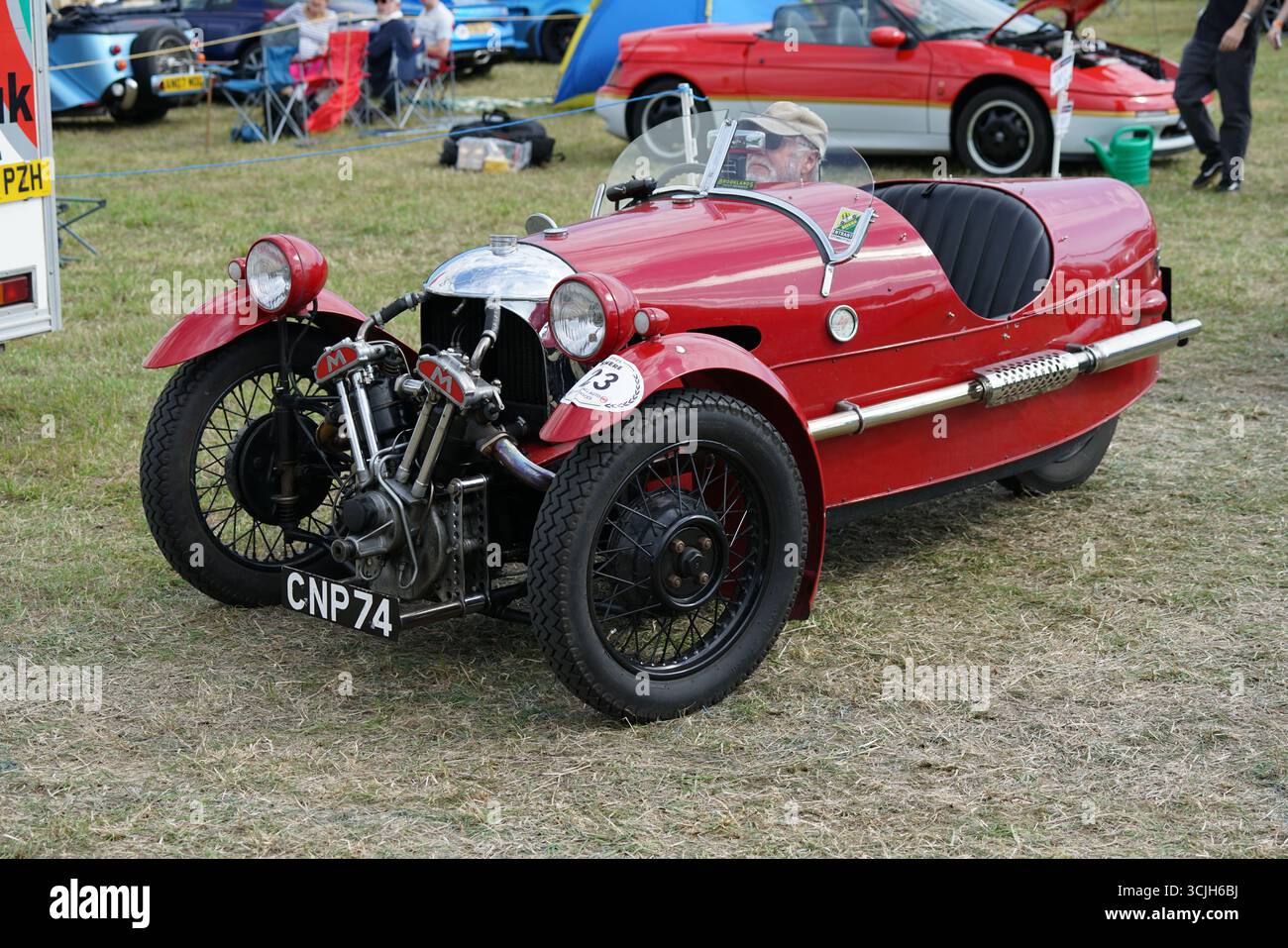 Auto d'epoca rossa a tre ruote in occasione di un evento automobilistico all'aperto. Shere Hill Climb, East Clandon, Guildford Foto Stock