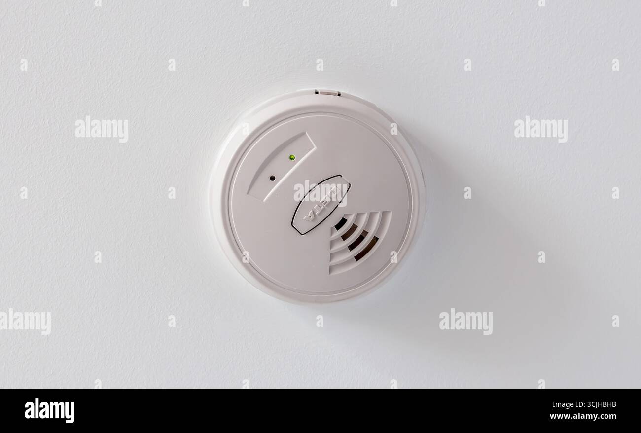 Un rilevatore di fumo domestico sul soffitto Foto Stock