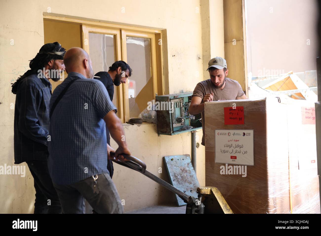 Gli operatori di soccorso scaricano la spedizione di aiuti medici del Qatar a Damasco per sostenere il recupero dopo Assad in Syrias gli operatori di soccorso scaricano scatole di aiuti medici fornite dal Qatar all'aeroporto internazionale di Damasco, parte del ponte umanitario a sostegno del recupero e della ricostruzione siriani dopo la caduta di Bashar al-Assad. Damasco Siria Copyright: XMohammadxBashirxAldaherx Foto Stock