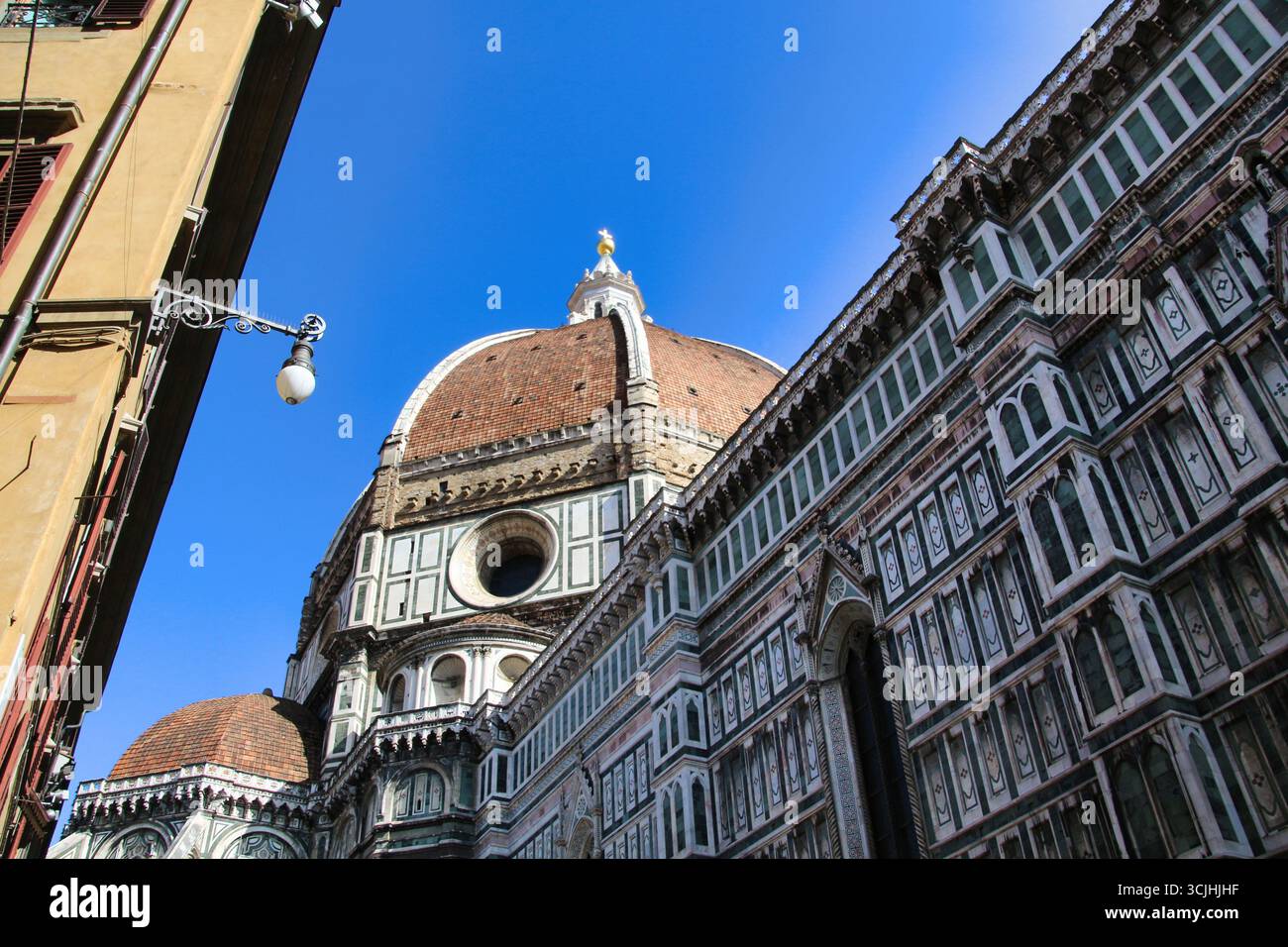 La cupola del Duomo di Firenze si affaccia su un cielo azzurro. Uno scatto dall'alto del magnifico Duomo di Firenze, in Italia, che mostra l'iconico Brunelleschi Foto Stock