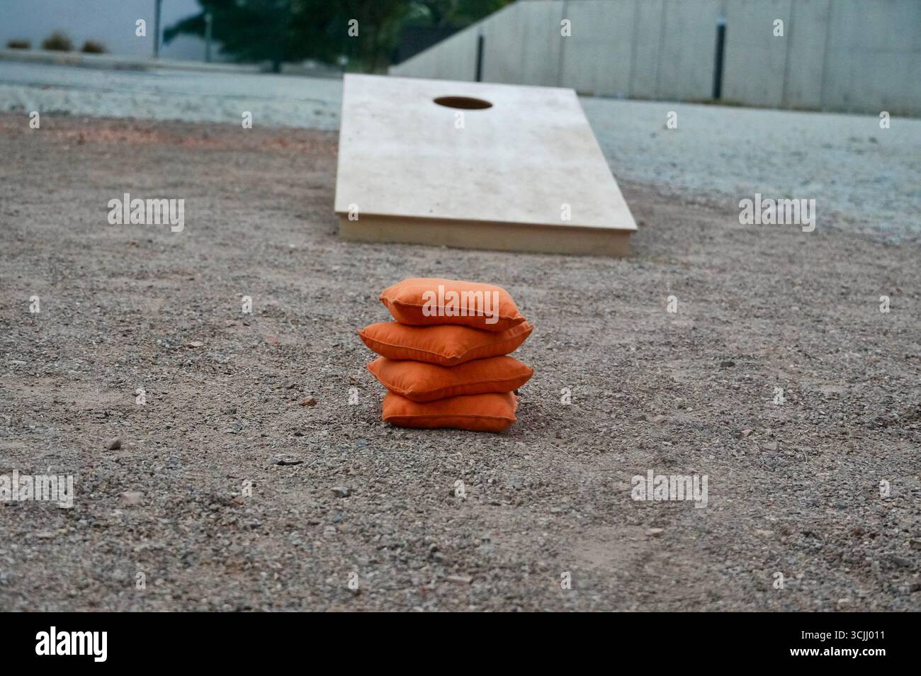 Una pila di cuscini arancioni a terra con una base in cemento Foto Stock