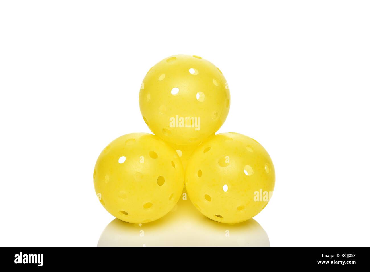 Una pila di palle di palline di pallina gialla su bianco. Foto Stock