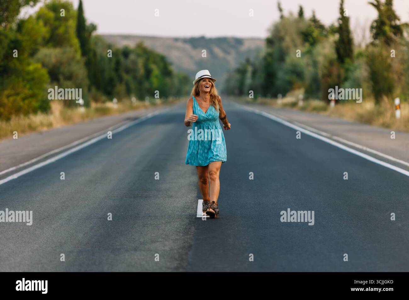 Buon turista che cammina su una strada di campagna durante le vacanze estive Foto Stock