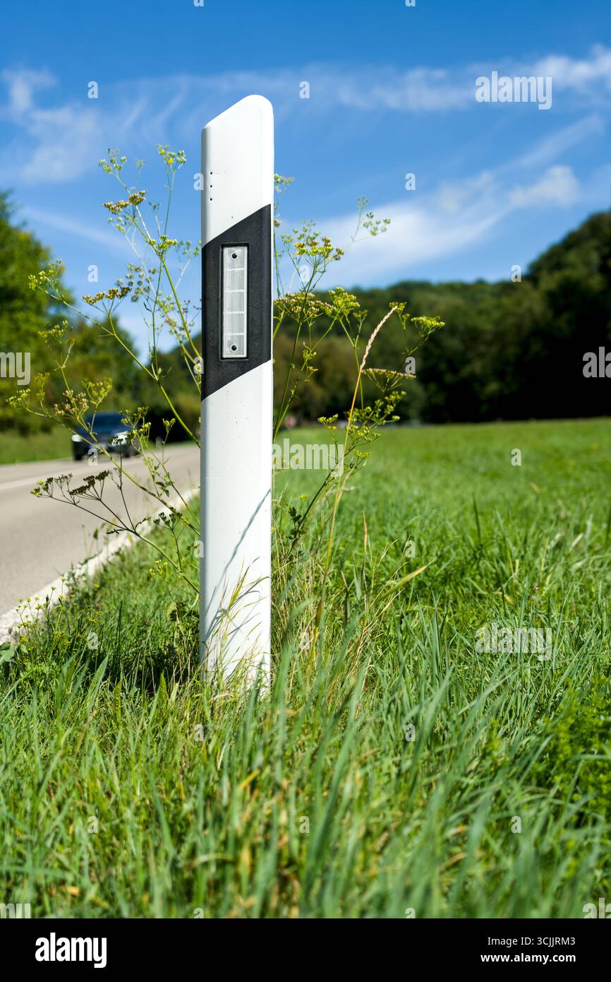 Primo piano di un palo delineatore lungo una strada di campagna. Foto Stock