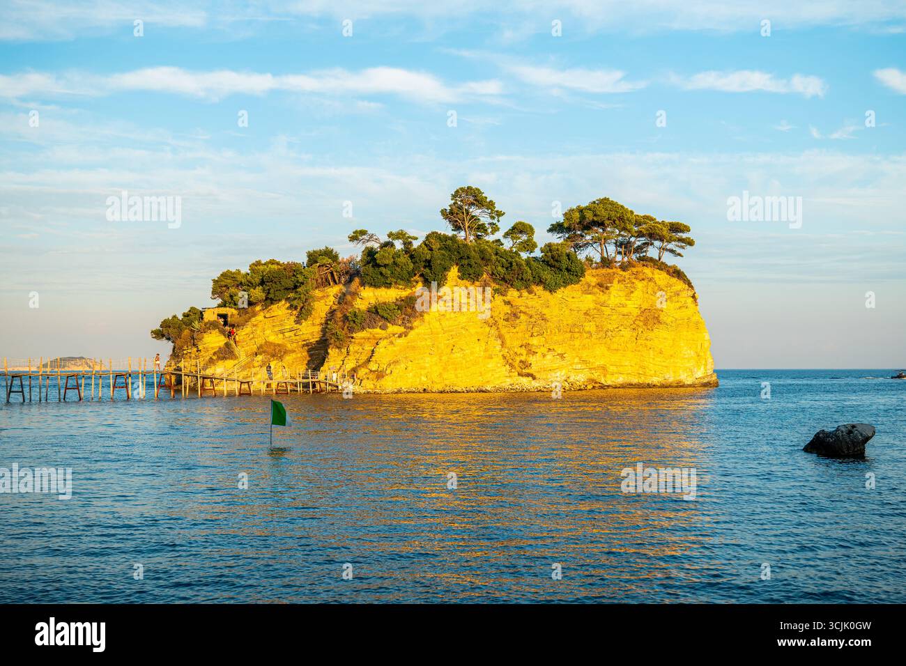 Isola cammeo Zante Grecia piccola isola rocciosa con alberi e ponte di legno circondata dal mare blu con luce solare notturna dorata sotto il cielo limpido Foto Stock Isola cammeo Zante Grecia piccola isola rocciosa con alberi e ponte di legno circondata dal mare blu con luce solare notturna dorata sotto il cielo limpido Foto Stock