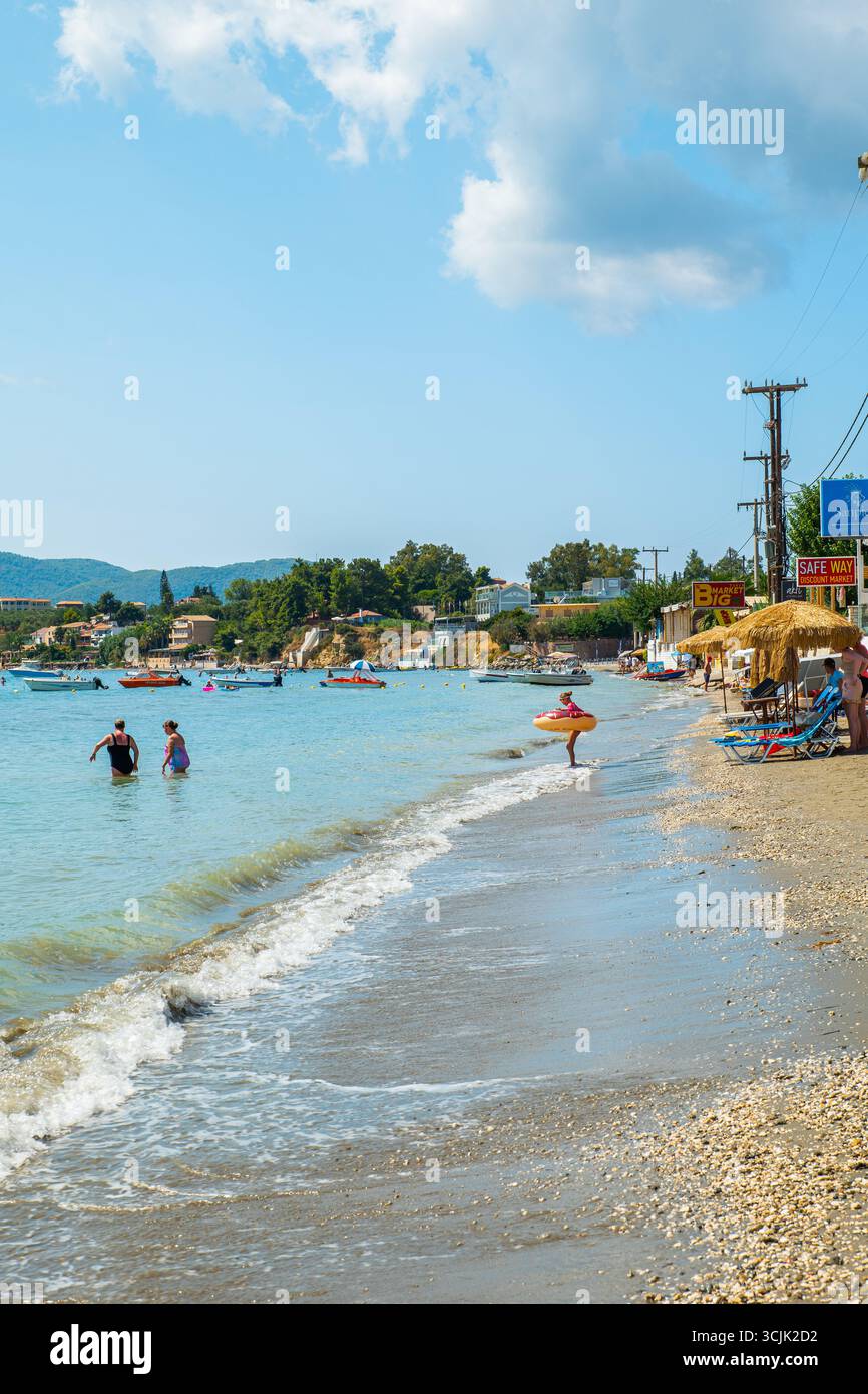 Laganas Beach, isola di Zante, Grecia, vista panoramica con persone che si rilassano sulle barche di sabbia in lontananza e cielo limpido sopra la costa Foto Stock Laganas Beach, isola di Zante, Grecia, vista panoramica con persone che si rilassano sulle barche di sabbia in lontananza e cielo limpido sopra la costa Foto Stock