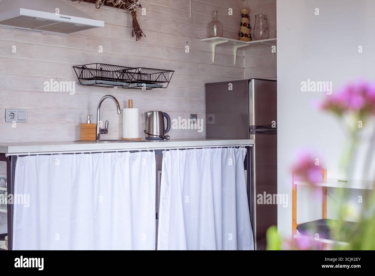 Gli interni luminosi della cucina scandinava presentano un design minimalista con elementi funzionali, creando un'atmosfera accogliente e ariosa, perfetta per i moderni Foto Stock