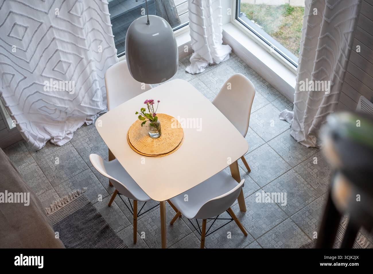 L'area pranzo scandinava minimalista presenta arredi funzionali, un ambiente luminoso e un arredamento accogliente, creando uno spazio invitante per il moderno wifi Foto Stock
