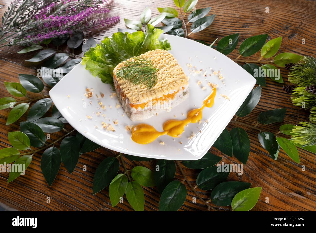 Una foto con Mimosa, una tradizionale insalata Ucraina a strati con pesce e maionese, presentata con colori vivaci e una texture delicata. Foto Stock