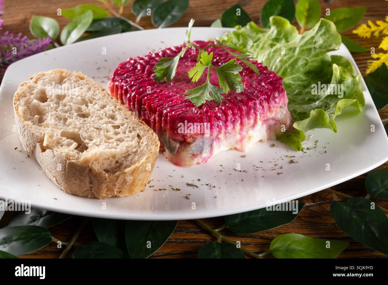 Una foto con Shuba, una tradizionale insalata Ucraina di aringhe a strati di barbabietole e maionese, presentata con colori vivaci e ricca consistenza. Foto Stock