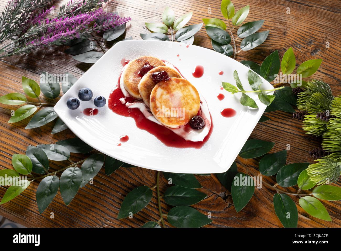 Una foto che mostra Sirniki, un tradizionale pancake al formaggio ucraino, presentato con un finale dorato e servito come deliziosa colazione o dessert Foto Stock