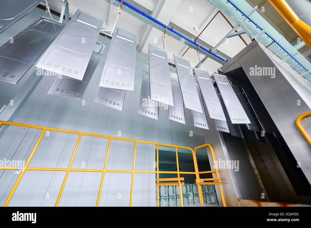 Parti metalliche sottoposte a sgrassatura e risciacquo in un'officina di verniciatura a polvere durante i processi industriali Foto Stock