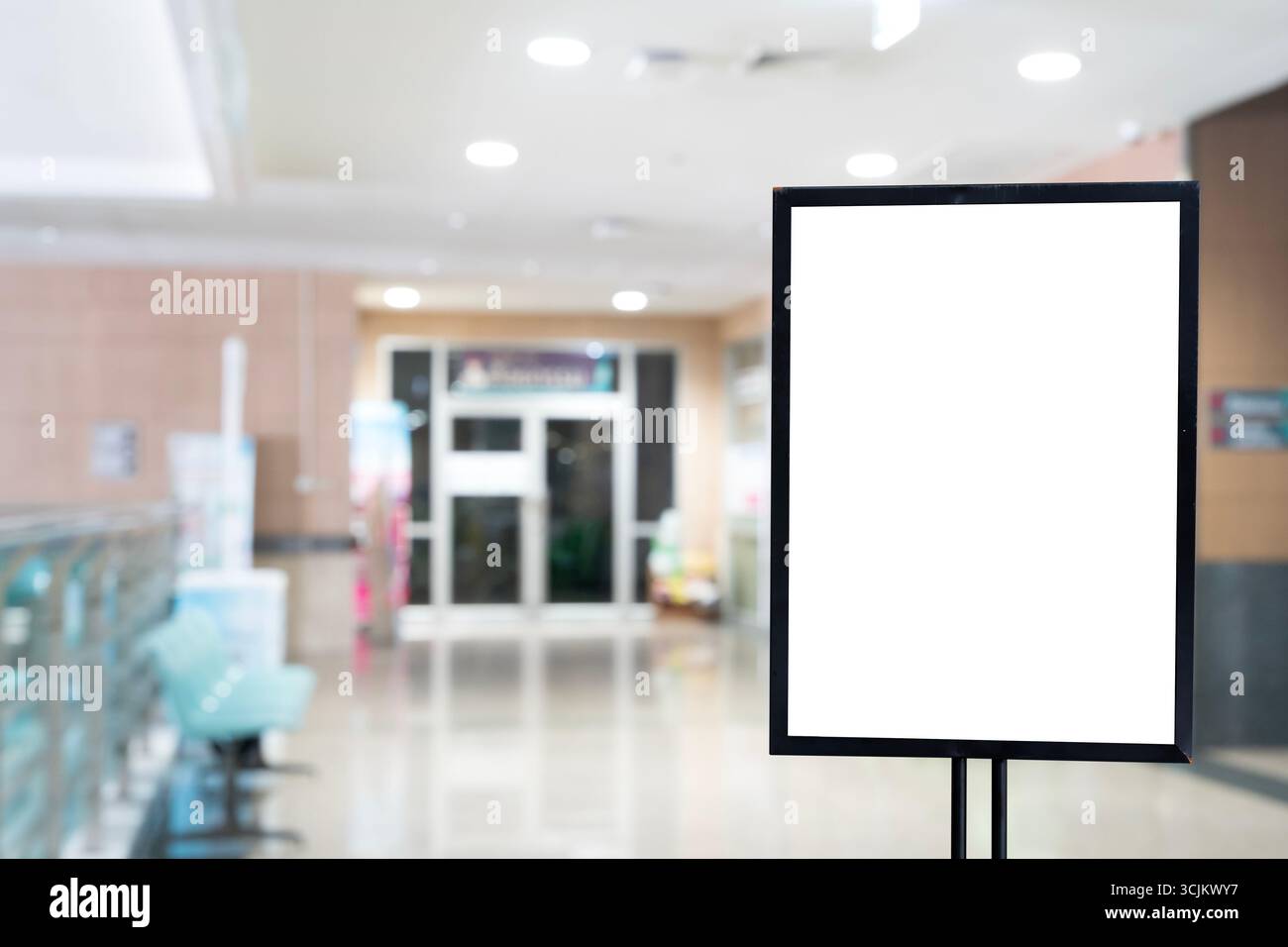 Modello di segnaletica vuoto con cornice nera posizionata nell'atrio dell'ospedale o dell'ufficio, isolato su sfondo sfocato, pubblicità vuota o boa promozionale Foto Stock