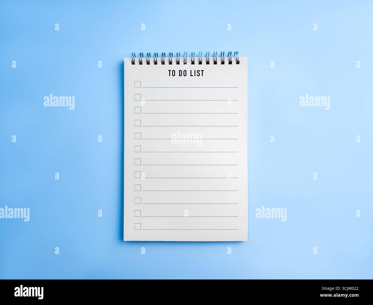 Elenco delle attività e modello di elenco di controllo su notebook a spirale con sfondo blu, che simboleggia la produttività, la gestione delle attività, la pianificazione, la gestione del tempo, e g Foto Stock