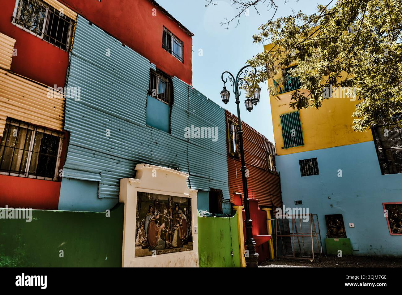 Buenos Aires, Argentina - 22 dicembre 2022: Vetrine, colorati edifici in metallo ondulato, murales e venditori ambulanti riempiono il quartiere di Caminito Foto Stock