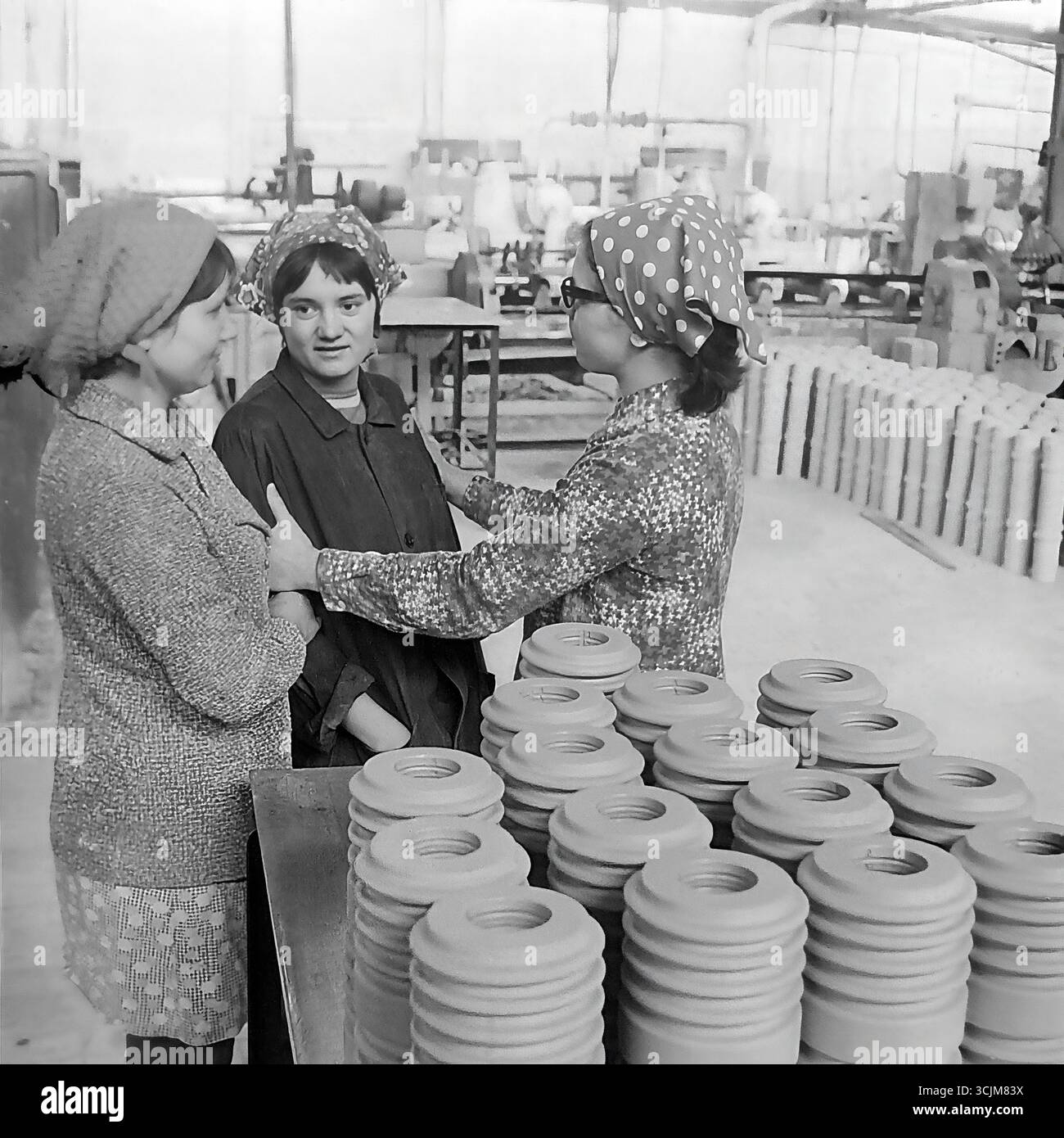 Tre lavoratrici in un laboratorio dell'impianto isolante ad alta tensione di Slavyansk (ZVI) durante una vivace conversazione durante una pausa, 1976. Questo sincero scatto d'archivio dell'era della stagnazione, che cattura l'amicizia e la moda degli anni '70 in un ambiente di lavoro, è un simbolo delle relazioni umane in un collettivo operaio e della vita serena di un Donbas pacifico Foto Stock