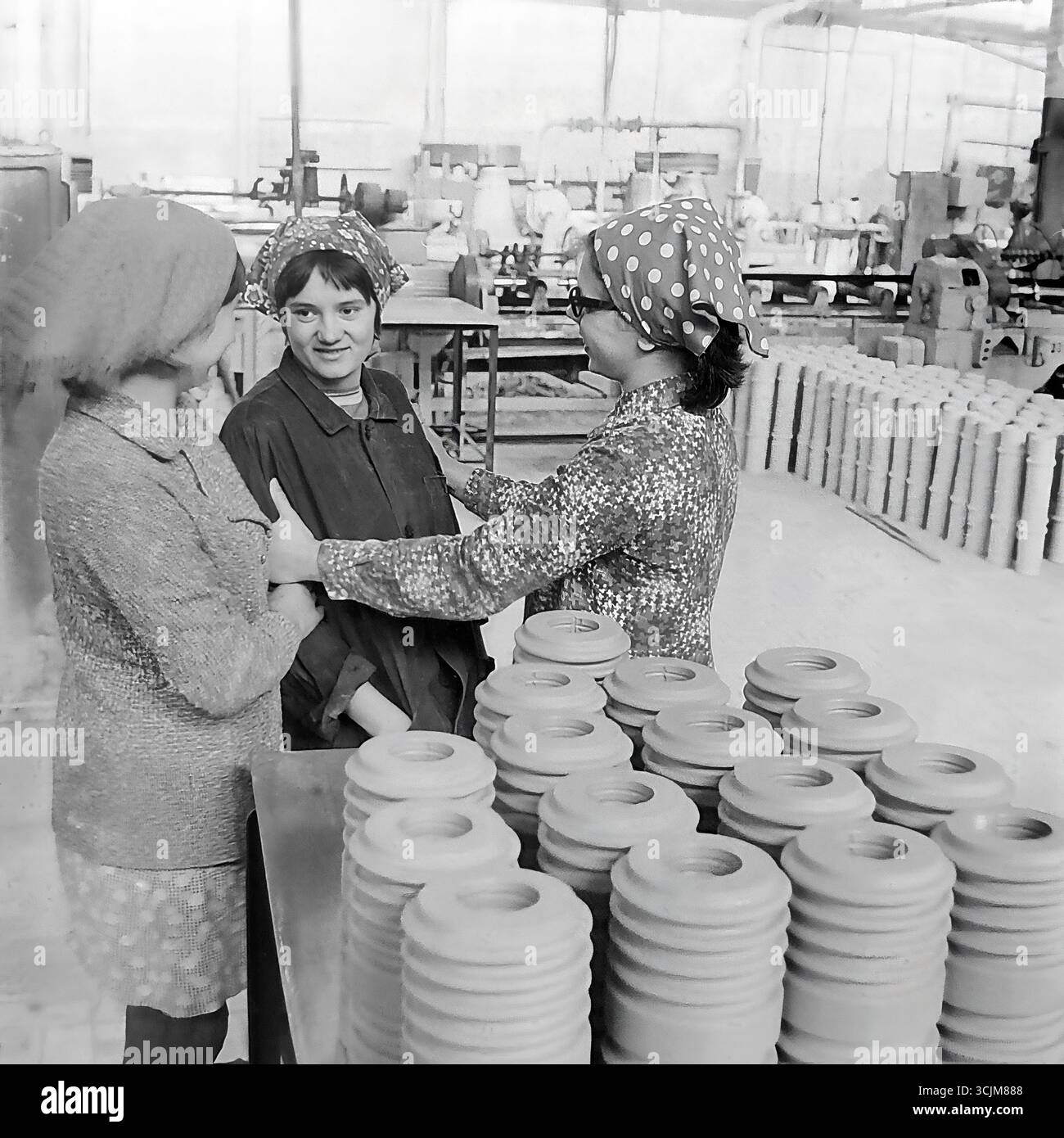 Tre lavoratrici in un laboratorio dell'impianto isolante ad alta tensione di Slavyansk (ZVI) durante una vivace conversazione durante una pausa, 1976. Questo sincero scatto d'archivio dell'era della stagnazione, che cattura l'amicizia e la moda degli anni '70 in un ambiente di lavoro, è un simbolo delle relazioni umane in un collettivo operaio e della vita serena di un Donbas pacifico Foto Stock
