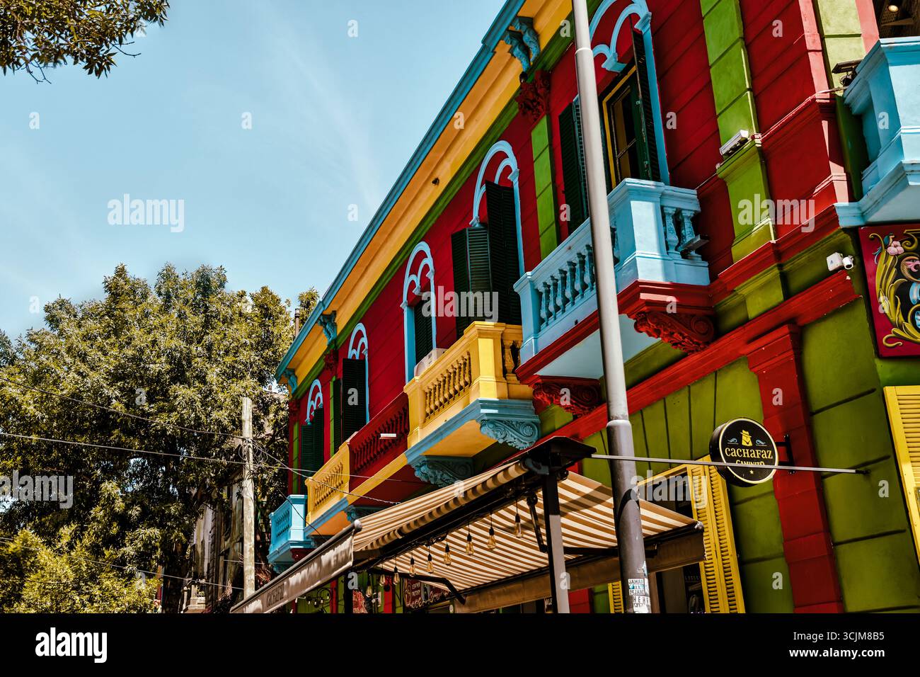 Buenos Aires, Argentina - 22 dicembre 2022: Vetrine, colorati edifici in metallo ondulato, murales e venditori ambulanti riempiono il quartiere di Caminito Foto Stock