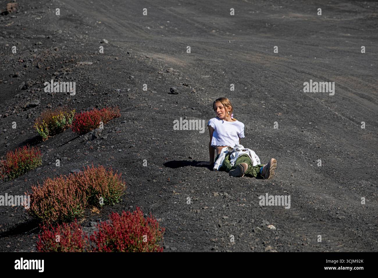 La ragazza riposa durante un'escursione sul vulcano Etna. Vacanze attive Foto Stock