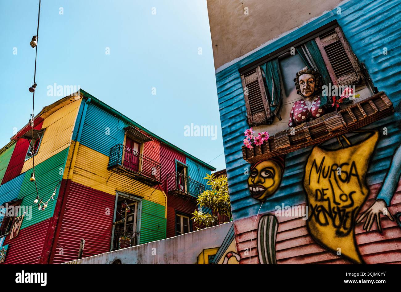 Buenos Aires, Argentina - 22 dicembre 2022: Vetrine, colorati edifici in metallo ondulato, murales e venditori ambulanti riempiono il quartiere di Caminito Foto Stock
