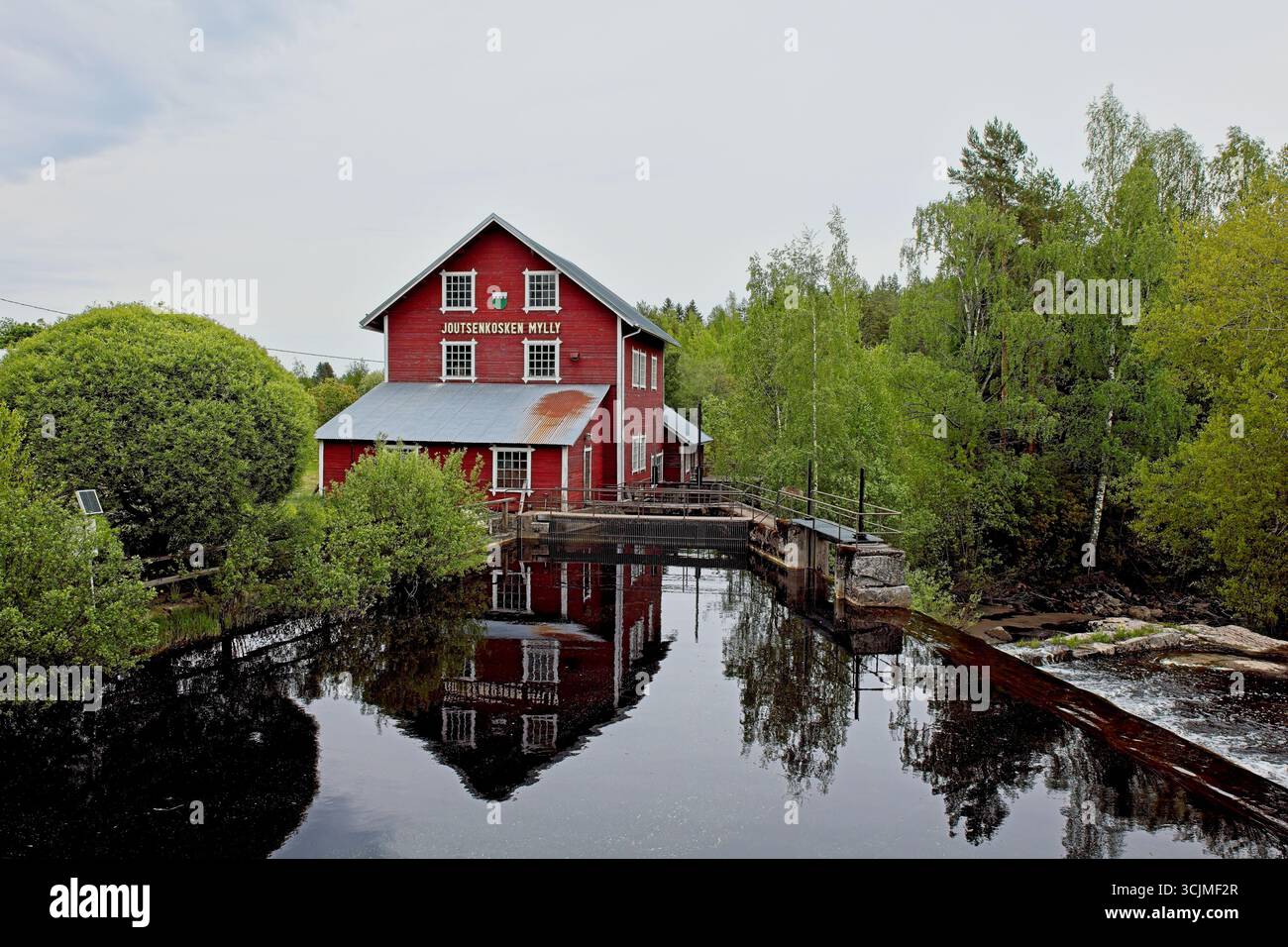 Il vecchio mulino in legno di Joutsenkoski (Joutsekosken mylly) con il clima nuvoloso primaverile, Ylämaa, Finlandia. Foto Stock