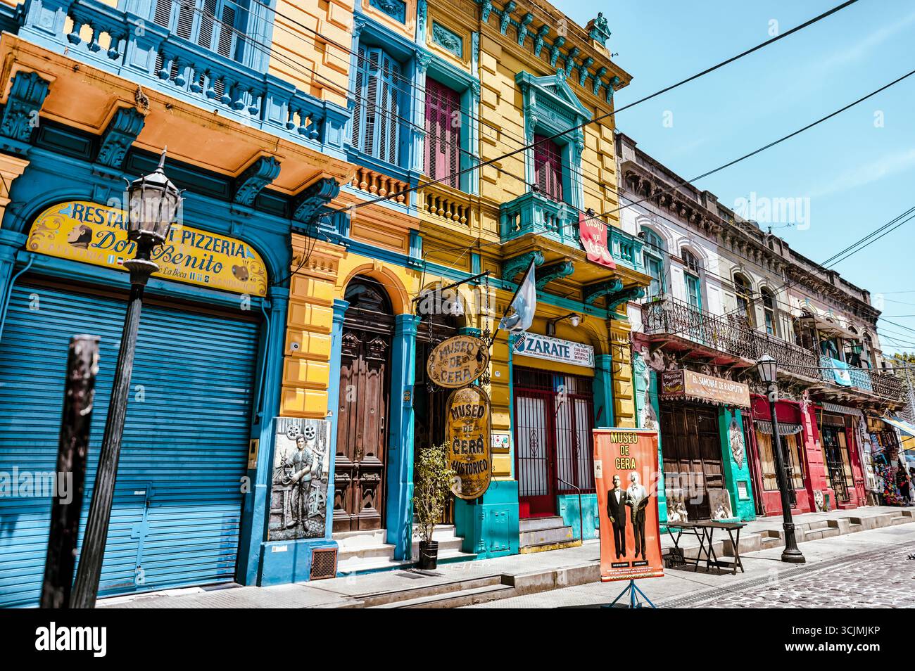 Buenos Aires, Argentina - 22 dicembre 2022: Vetrine, colorati edifici in metallo ondulato, murales e venditori ambulanti riempiono il quartiere di Caminito Foto Stock