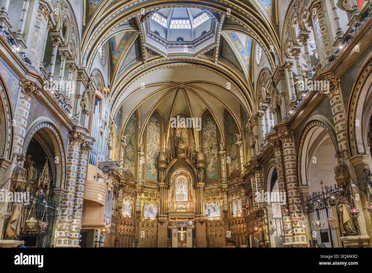 Magnifico edificio in stile neogotico con interni della Basilica del monastero di Montserrat con altare dorato decorato e soffitto a cupola. Santuario della chiesa cattolica Foto Stock
