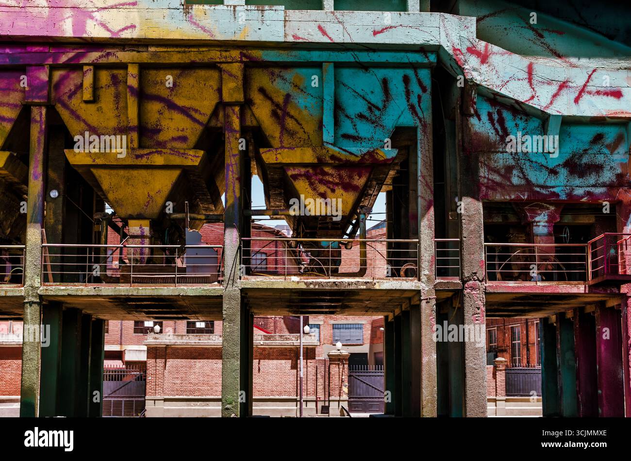 Buenos Aires, Argentina - 21 dicembre 2022: Strutture industriali ricoperte di graffiti e pilastri di cemento dominano il paesaggio urbano. Foto Stock