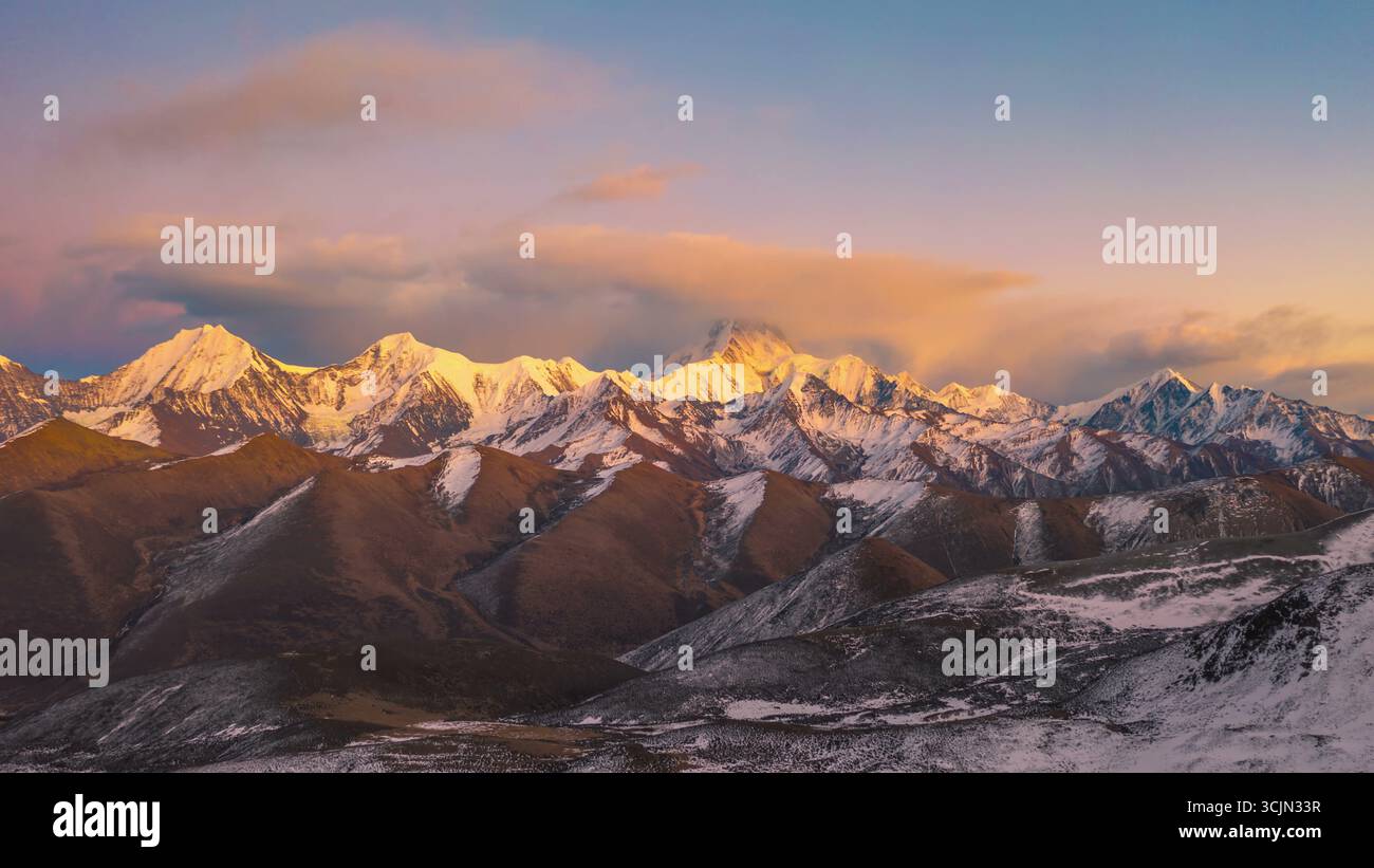 Catena montuosa all'alba con un bagliore dorato Foto Stock
