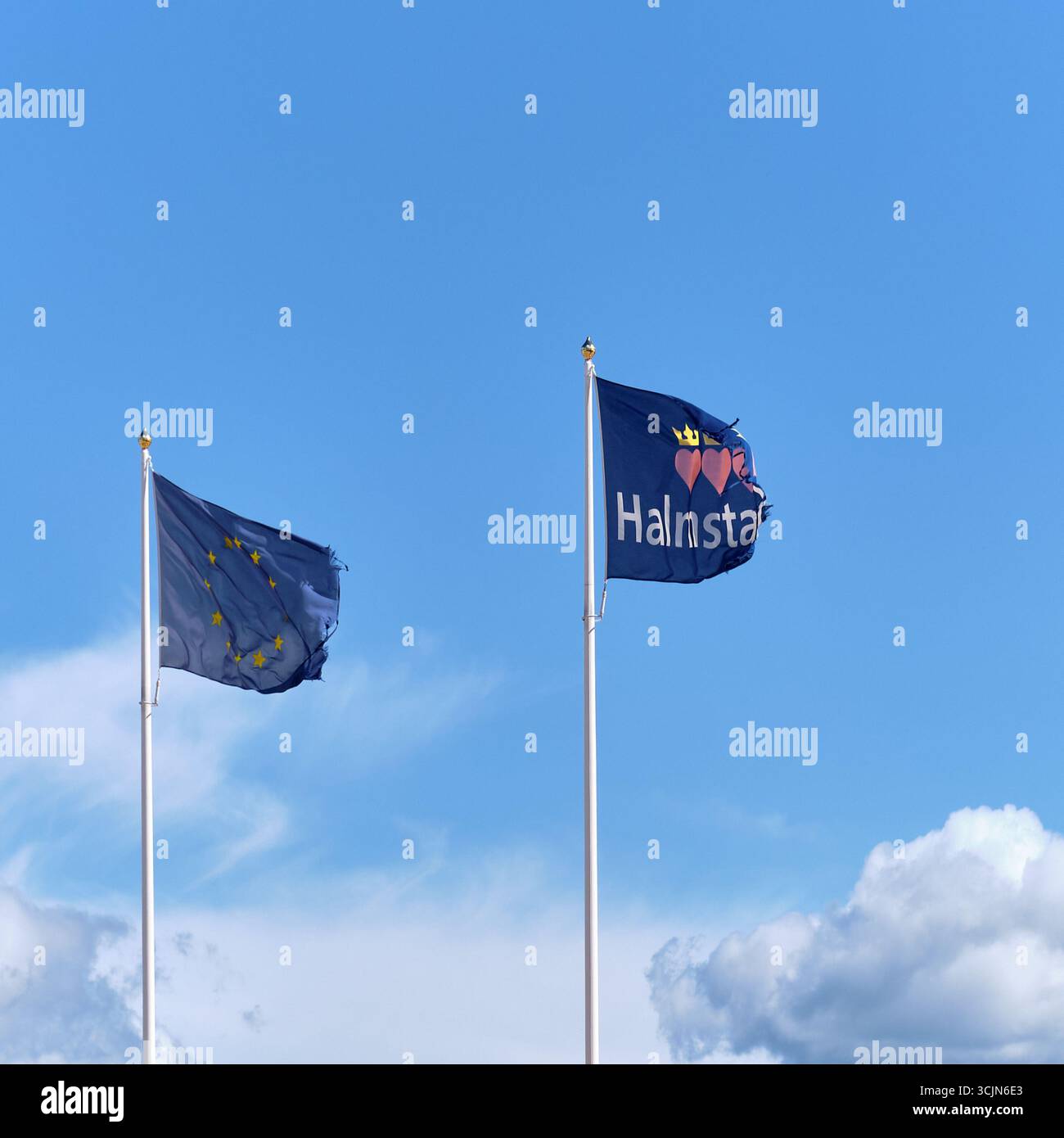 Halmstad, Svezia; 25 agosto 2023: Bandiera dell'Unione europea e bandiera municipale di Halmstad che battono nel cantiere di Södra Infarten fase due infrastruc Foto Stock