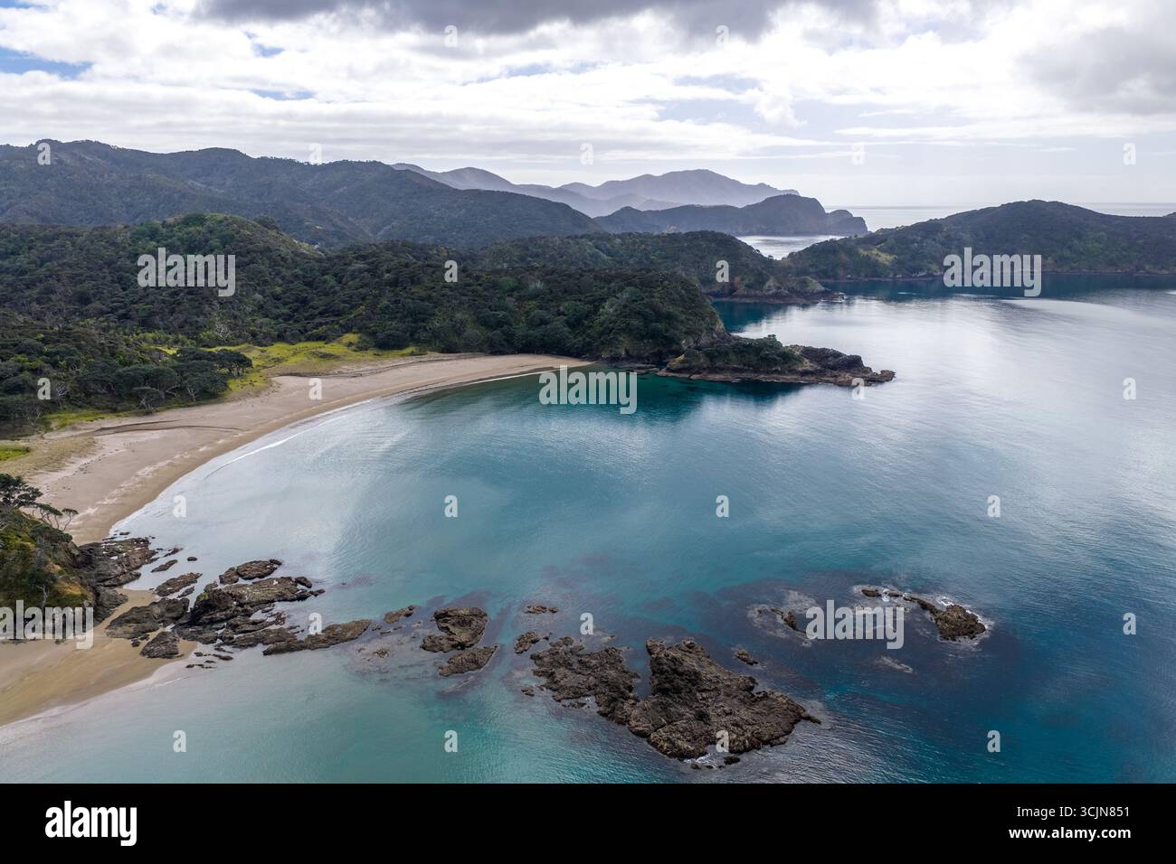 Vista aerea della spiaggia sabbiosa di Elliots Bay che abbraccia le acque turchesi, dove le rocce aspre incontrano la lussureggiante vegetazione delle colline, Elliots Bay, Northlan Foto Stock