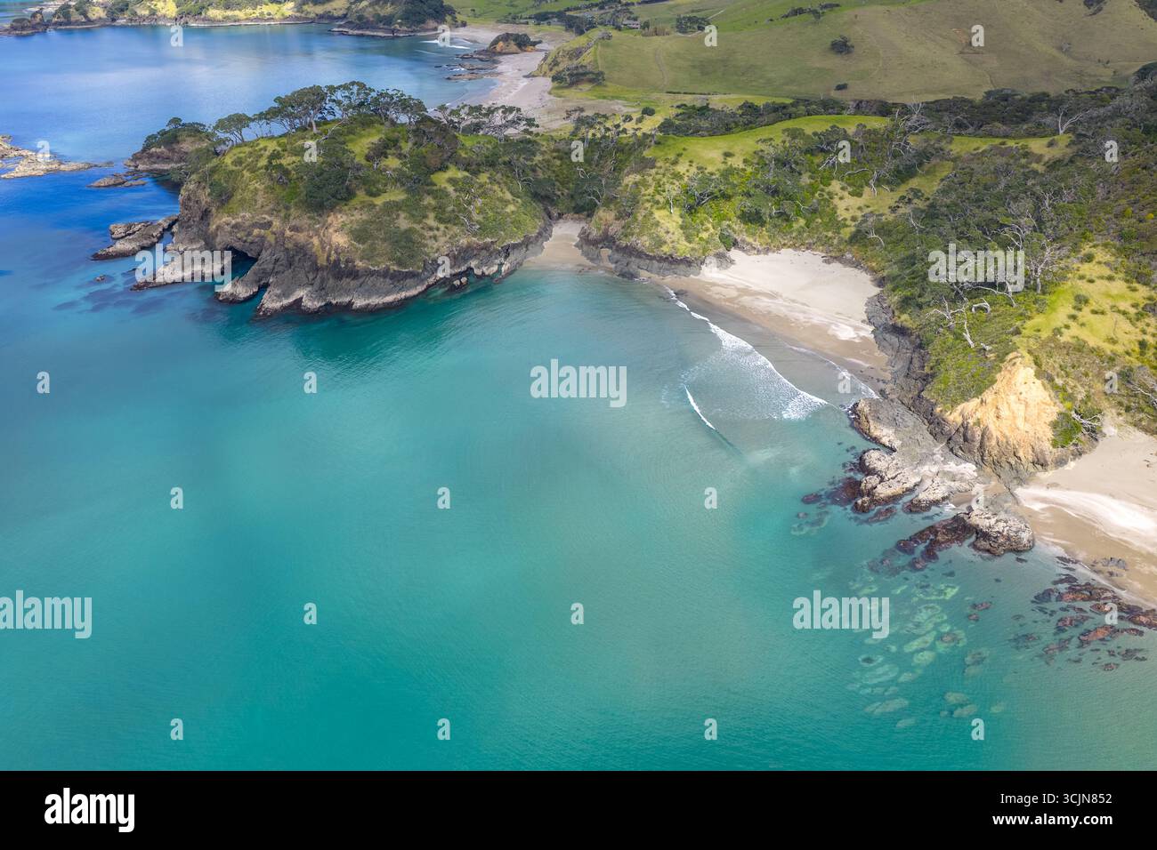Vista aerea del punto in cui le acque turchesi si incontrano con le coste sabbiose e i lussureggianti promontori verdi, Elliots Bay, regione del Northland, nuova Zelanda. Foto Stock