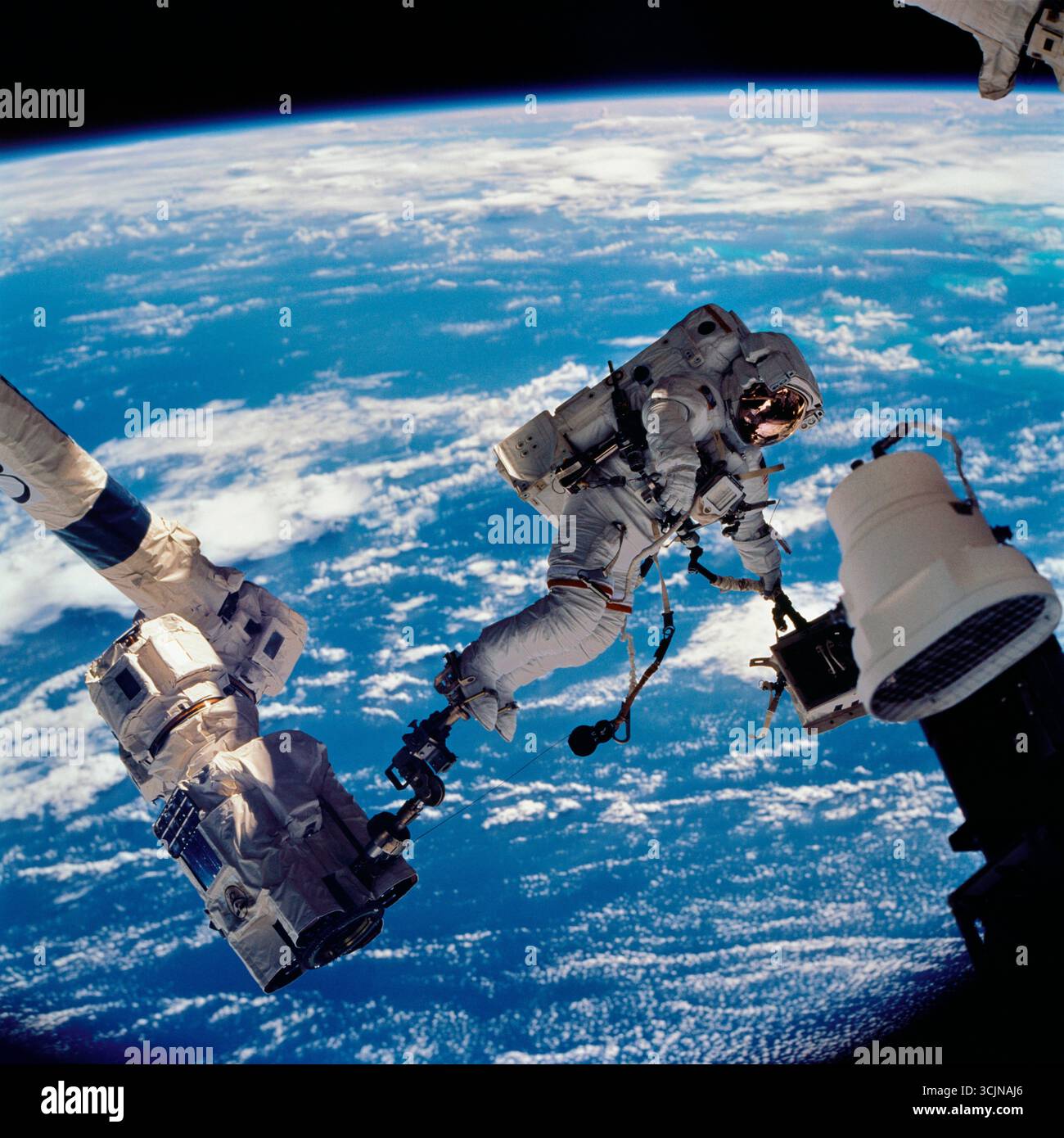 TERRA - 10 ottobre 2002 - l'astronauta della NASA David Wolf, specialista della missione STS-112, ancorato a un poggiapiedi sul Remote Manipulator della stazione spaziale Foto Stock