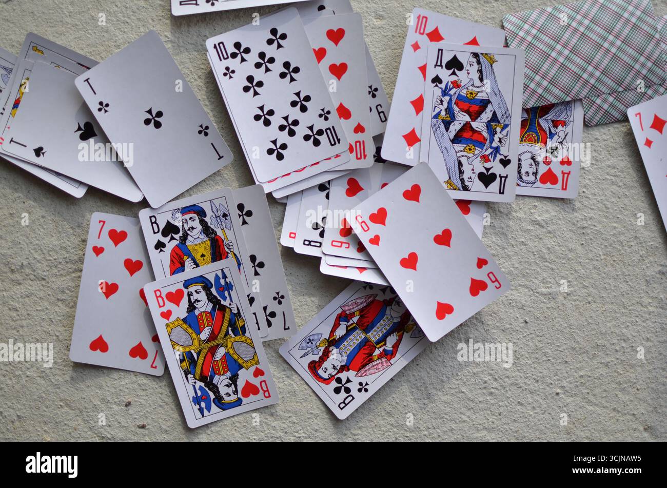 Un mazzo di carte da gioco è sparso sul pavimento, sullo sfondo. Foto Stock