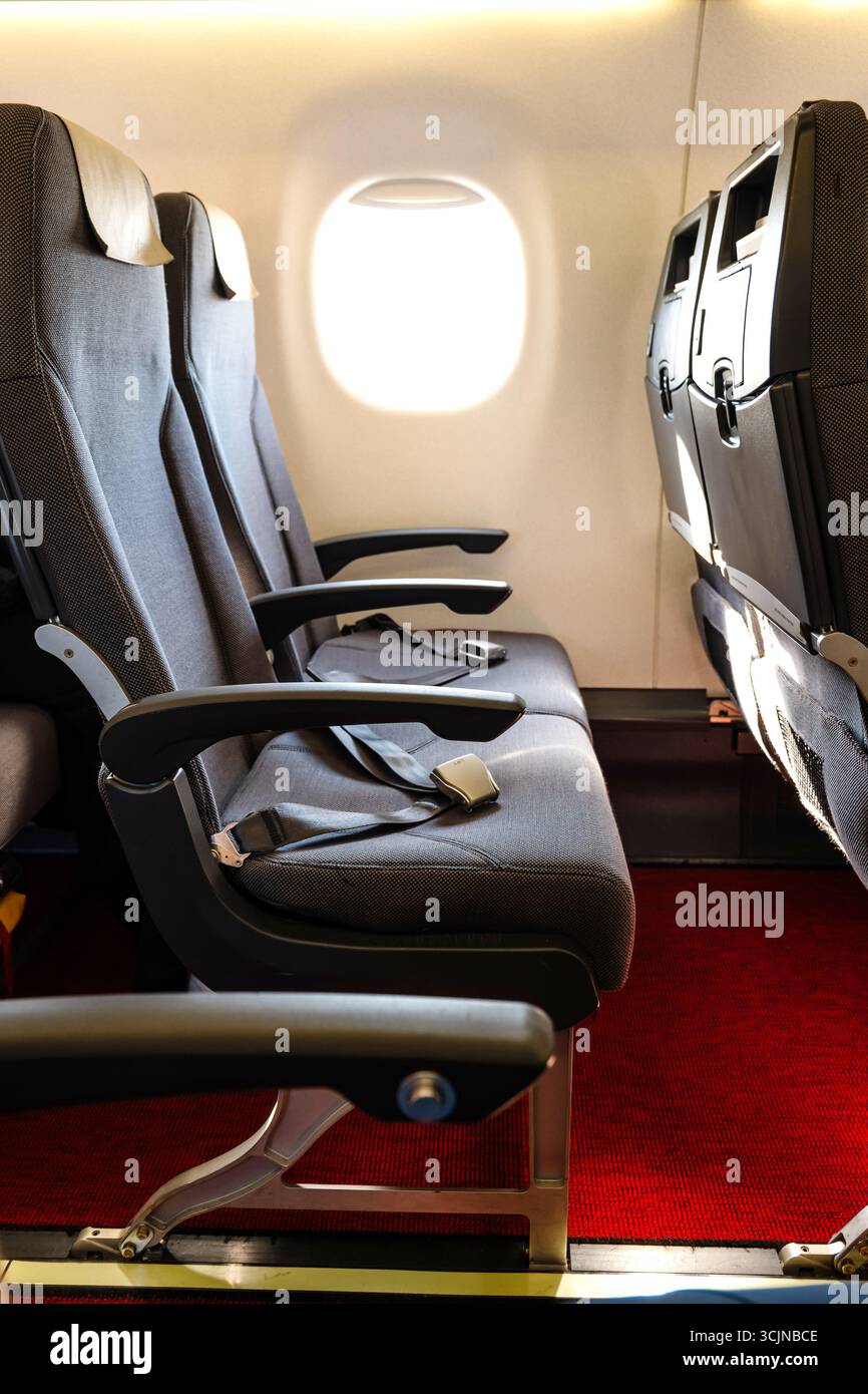Posti a sedere vuoti all'interno dell'aereo passeggeri commerciale, nessuna persona, vista grandangolare, luce finestrino Foto Stock