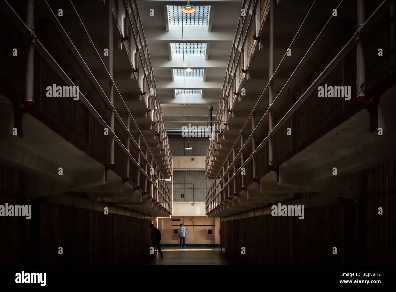 La vista degli aspri blocchi di celle della prigione di Alcatraz si estende nella luce soffusa, gettando lunghe ombre in uno storico penitenziario, San Francisco, California, Unit Foto Stock