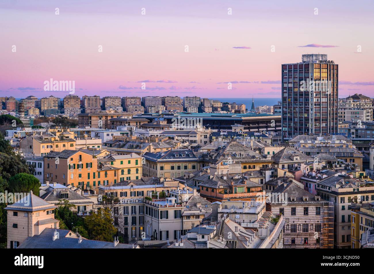 Il crepuscolo proietta una luce magica sui diversi tetti di Genova, in Italia, incantando lo skyline. Foto Stock