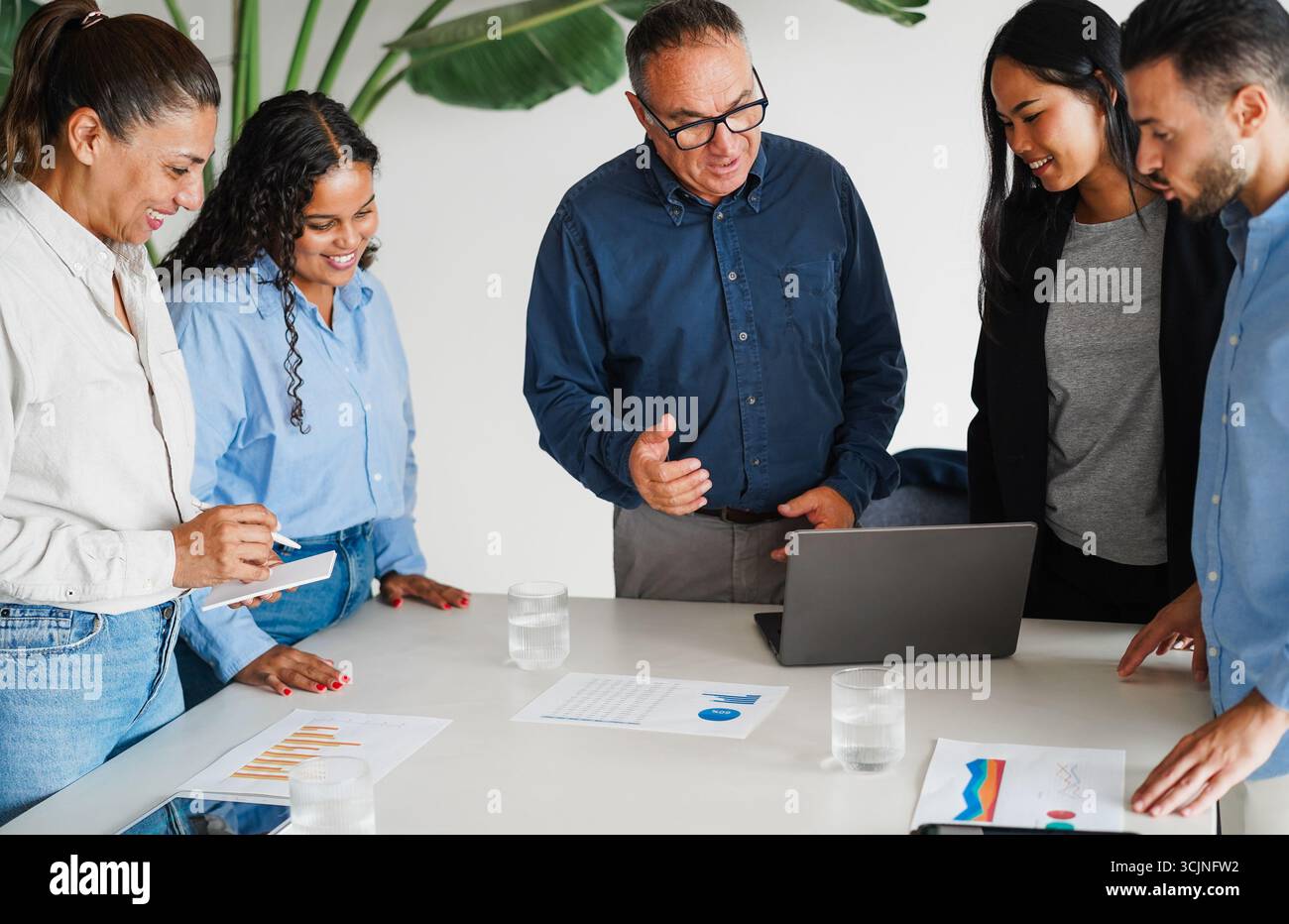 Uomini d'affari multigenerazionali che condividono idee all'interno dell'ufficio aziendale - colleghi multirazziali che discutono di nuovi progetti finanziari - brainstorming Foto Stock