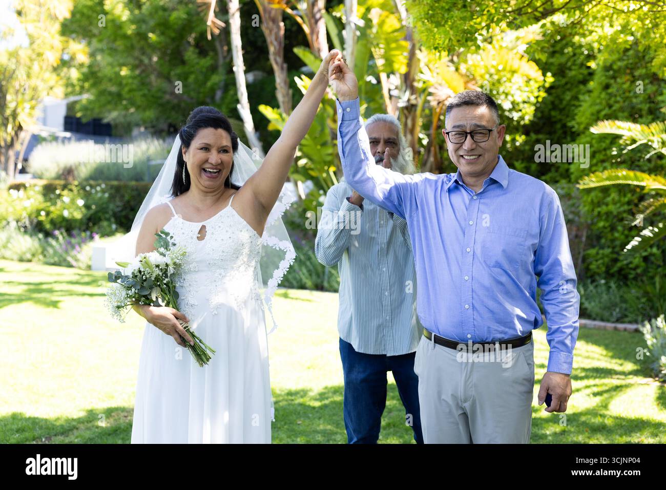 Festeggia all'aperto, sposa con bouquet e sorridente con tutta la famiglia Foto Stock