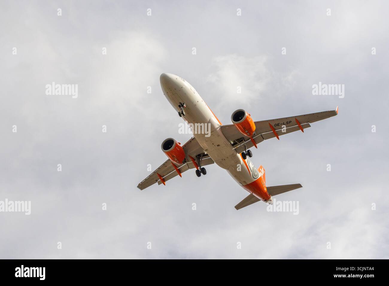 L'aereo airbus a320 di EasyJet vola in un cielo nuvoloso, mostrando la sua livrea arancione e bianca unica Foto Stock L'aereo airbus a320 di EasyJet vola in un cielo nuvoloso, mostrando la sua livrea arancione e bianca unica Foto Stock