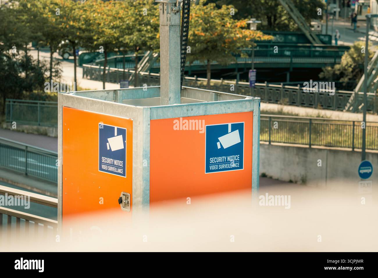 Avviso di sicurezza videosorveglianza monitoraggio dell'area urbana. Segnali di avvertimento che indicano la sorveglianza CCTV attiva su un pannello arancione luminoso in una città moderna Foto Stock