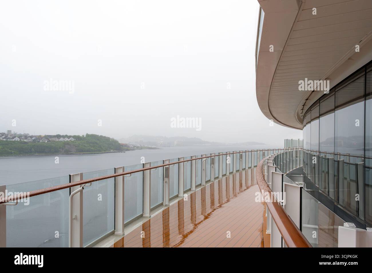 Una vista della costa norvegese, vicino a Stavanger, da una grande nave da crociera. È possibile vedere il ponte della nave da crociera. Il giorno piove e nuvoloso Foto Stock