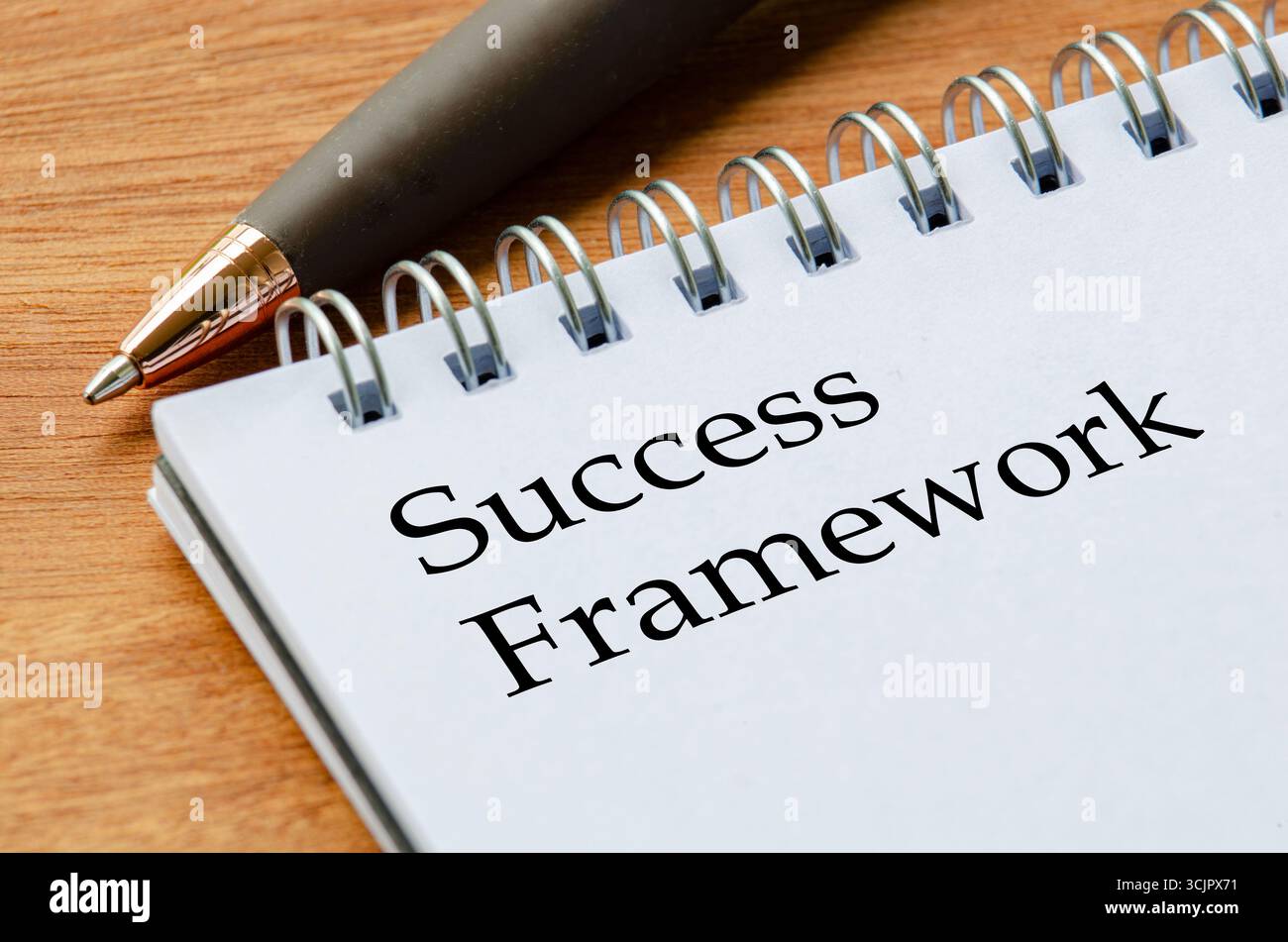 Blocco note primo piano con testo Success Framework su pagine con linee bianche a fuoco Foto Stock